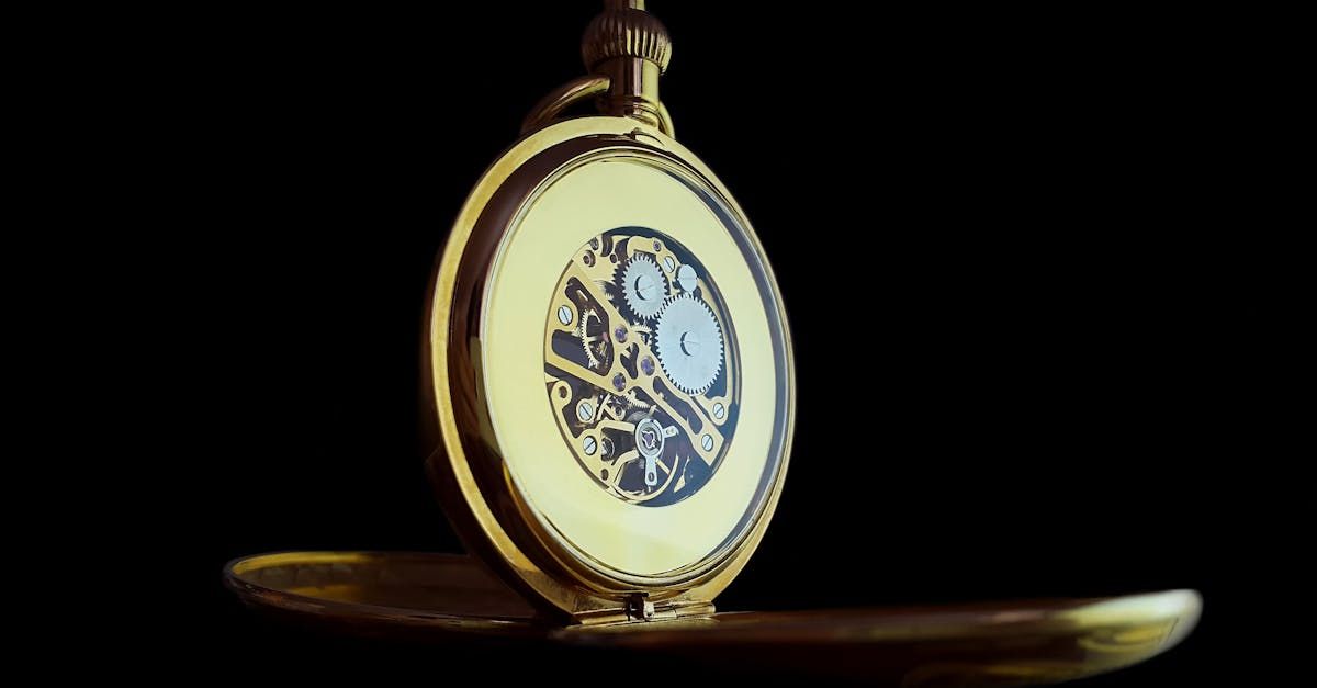 A close up of a pocket watch on a black background.