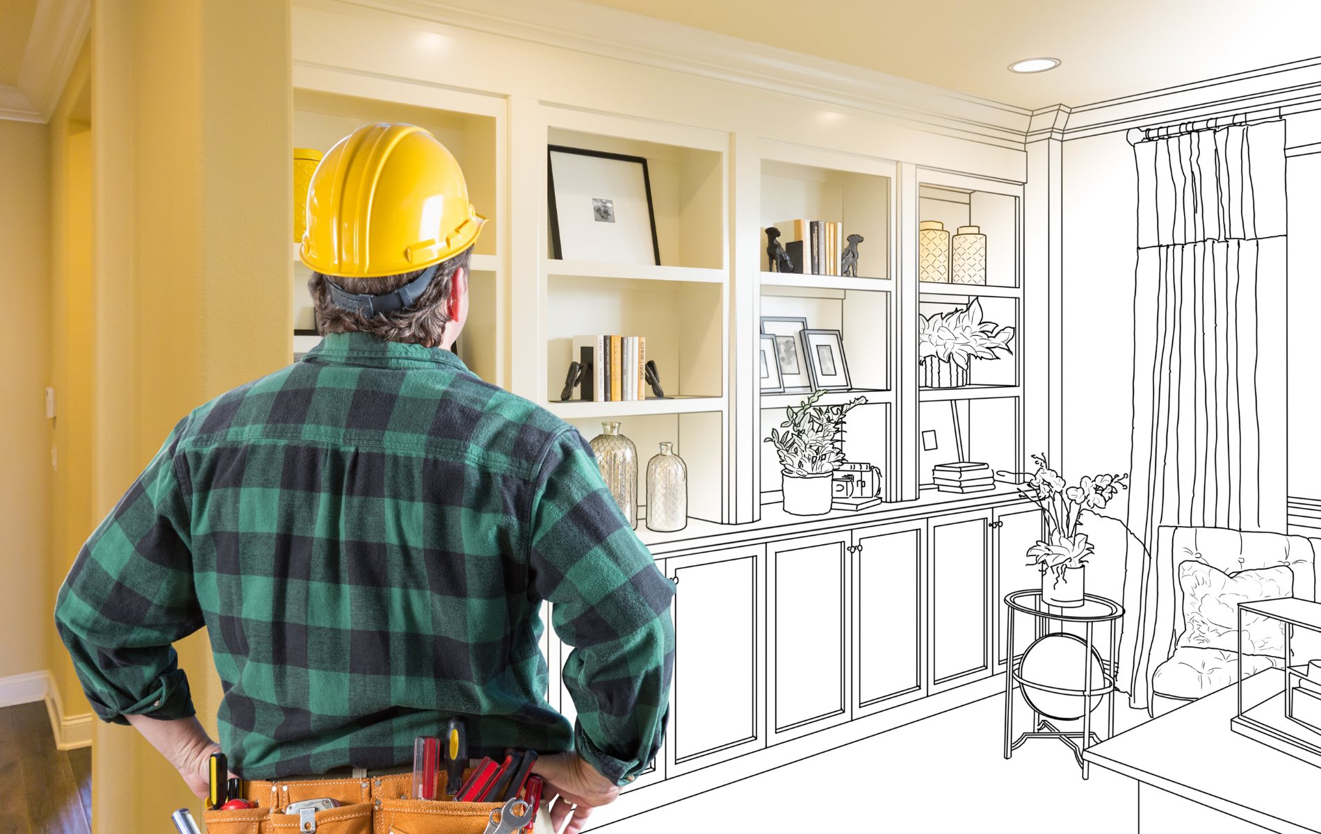 Construction worker with yellow hard hat, looking at a room design with partially built shelves.