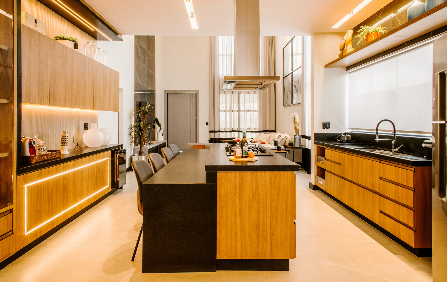 Modern kitchen with wooden cabinets, black countertops, and a large island.