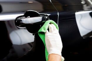 Worker cleaning black car - Auto Body Services in Talleyville DE