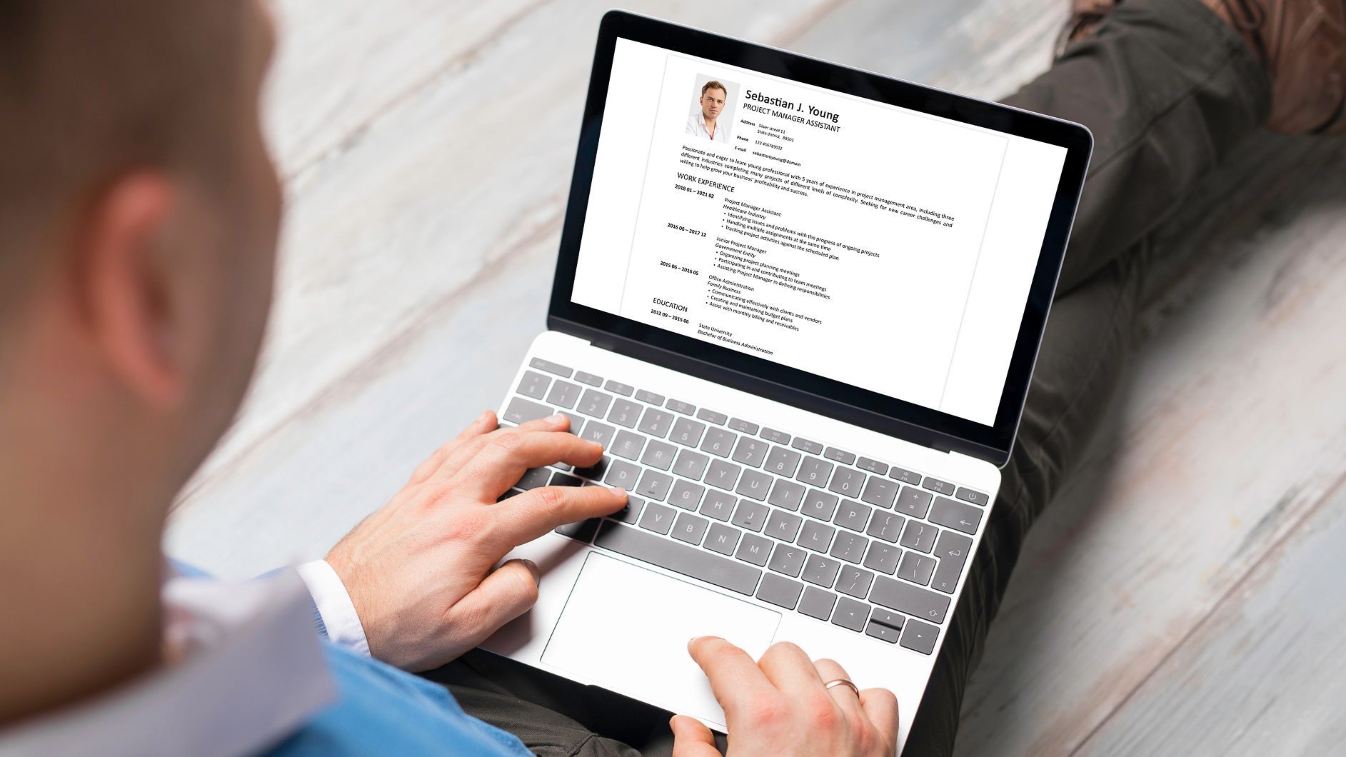 Man writing a resume on a laptop