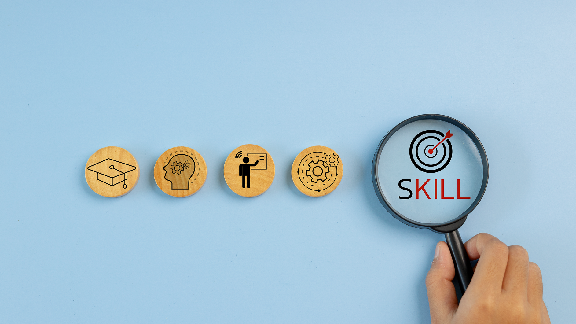 Wooden blocks and skill icons with a magnifying glass highlighting skill words, skill enhancement