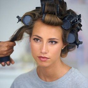 a lady getting her hair curled