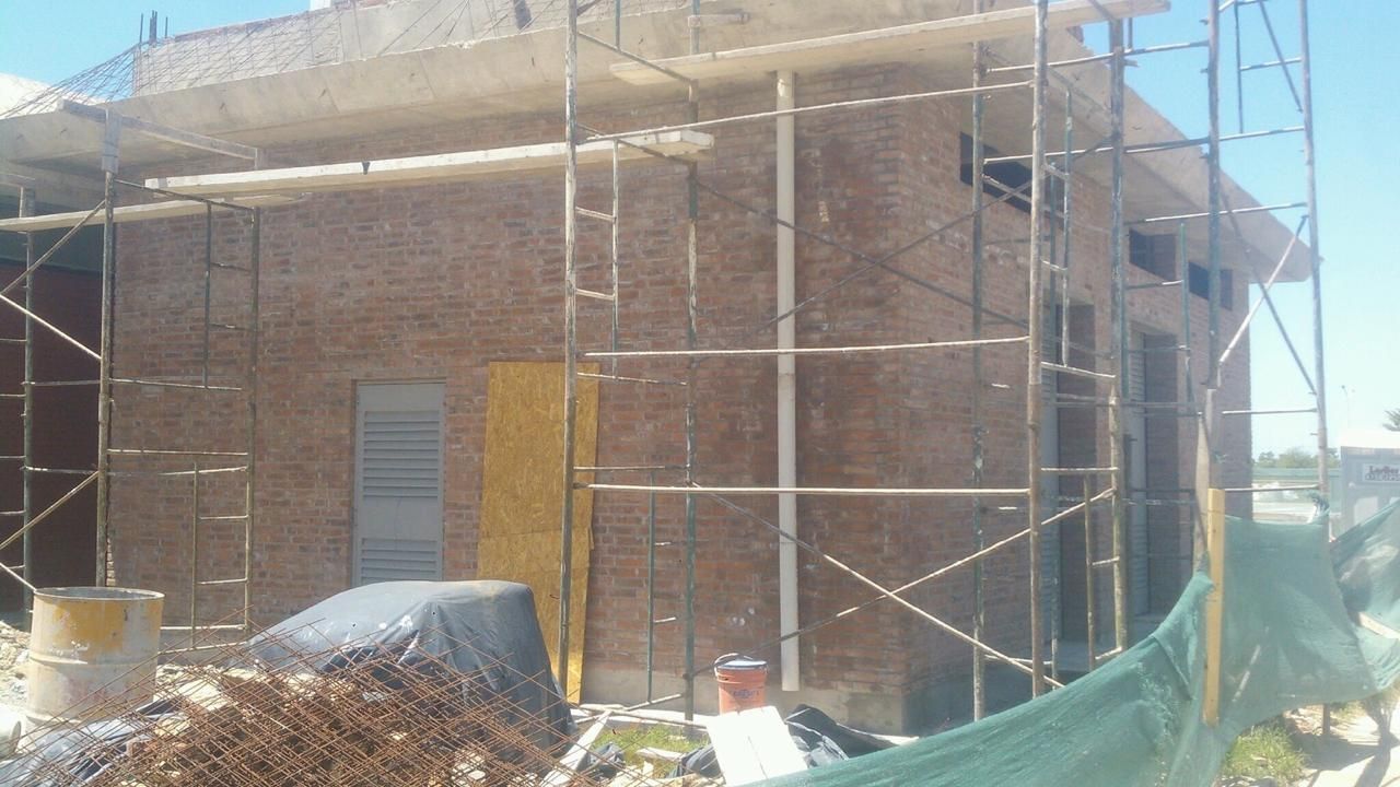 Edificio de ladrillo en construcción con andamios.