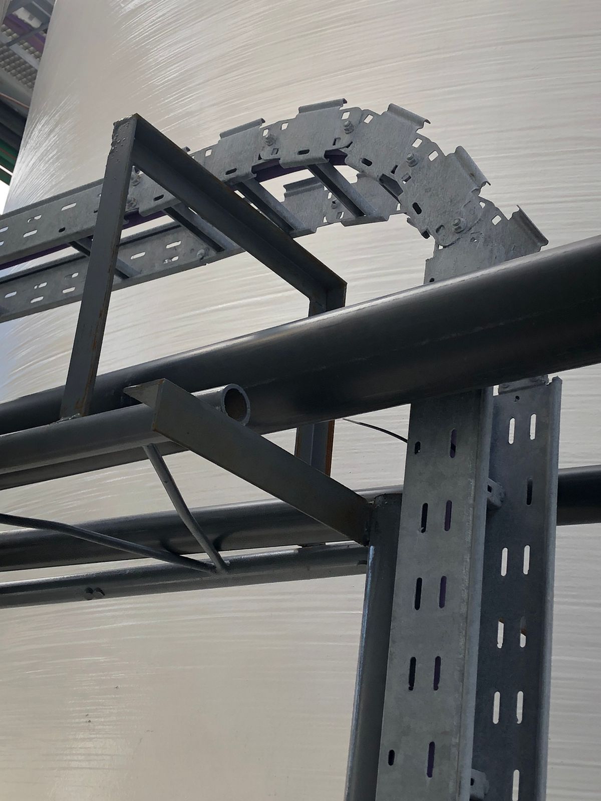 Estantería metálica con pasacables curvo, posiblemente en entorno industrial.