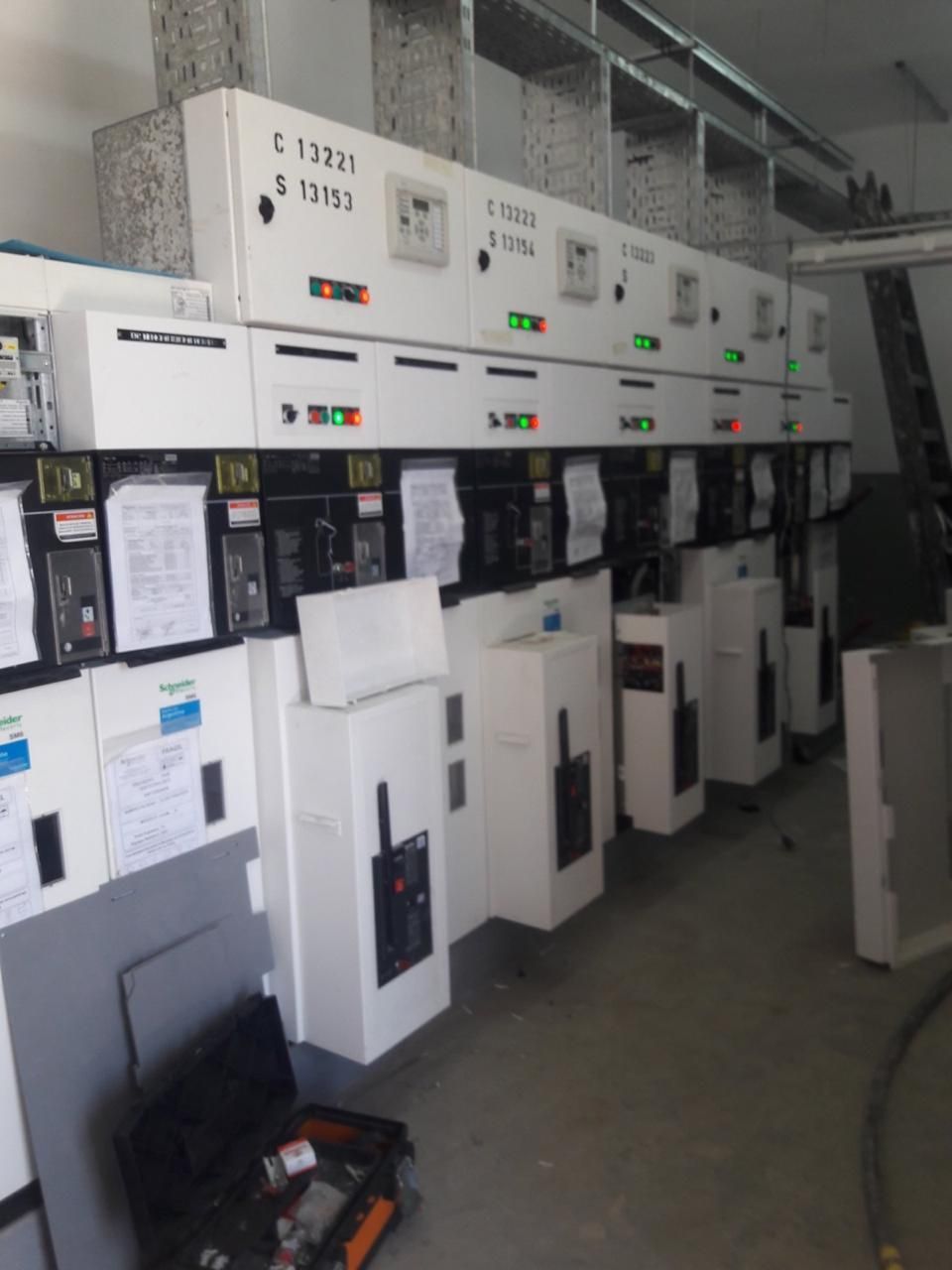 Equipo de cuadro eléctrico de control, de color blanco con indicadores verde/rojo, instalado en un edificio.