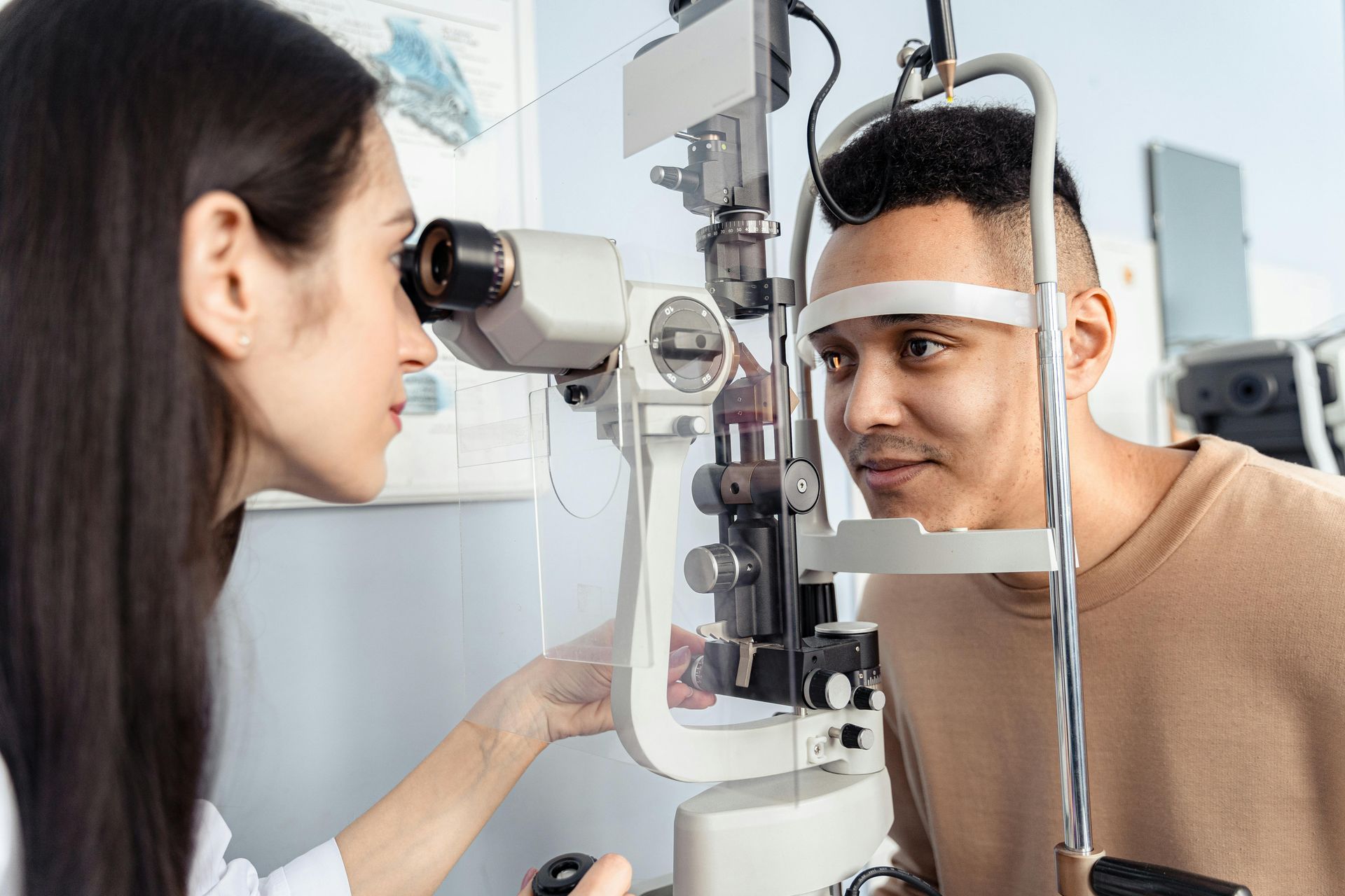 Optometrista examinando el ojo de un paciente con una lámpara de hendidura en una clínica oftalmológica.