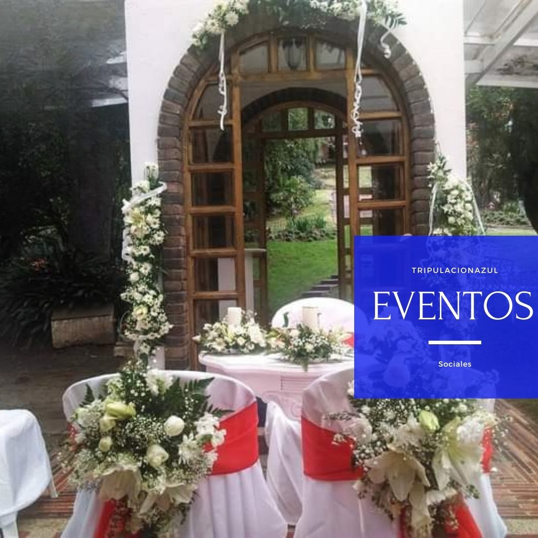 Escenario de ceremonia de boda con arreglos florales blancos y rojos.