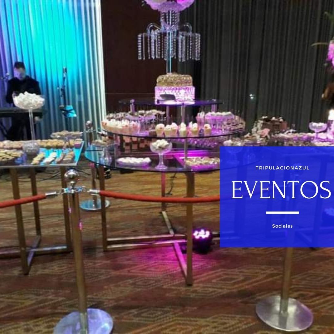 Buffet de postres en un evento con banda, mesas doradas y un pastel de varios niveles.