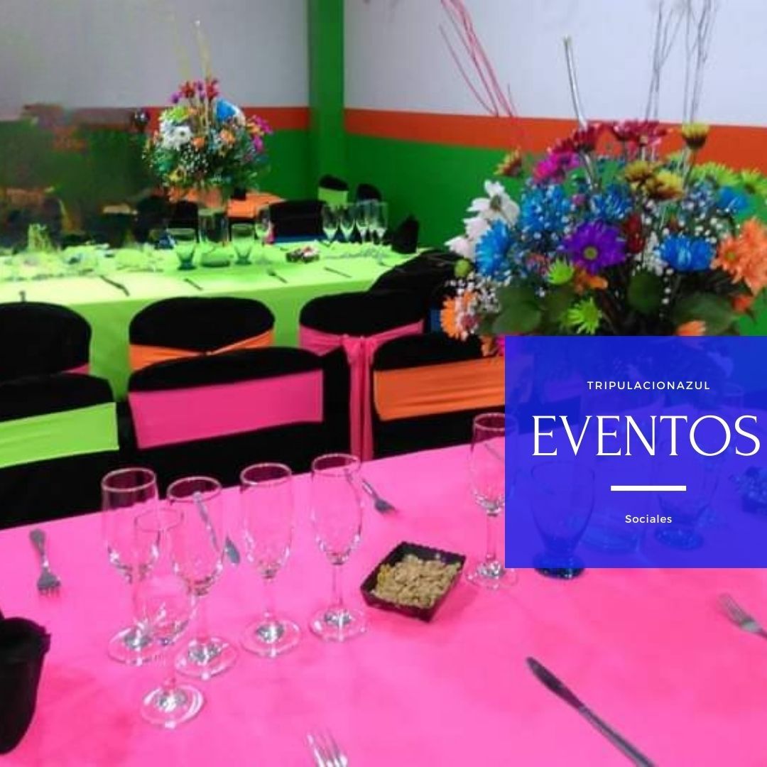 Mesas para eventos decoradas: colores vivos, flores, cristalería y sillas negras.