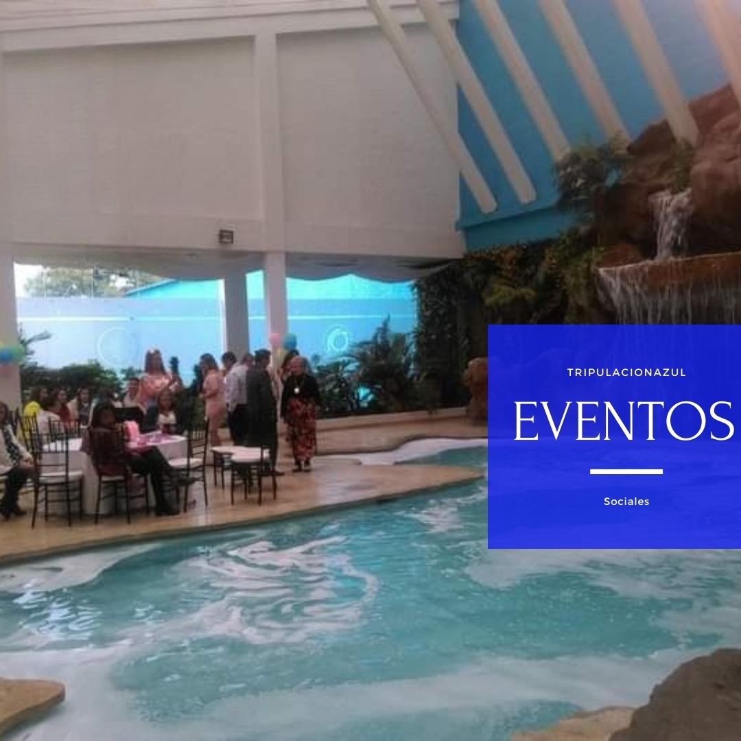 Espacio para eventos con piscina, mesas e invitados cerca de una cascada. Logotipo azul en la esquina derecha.