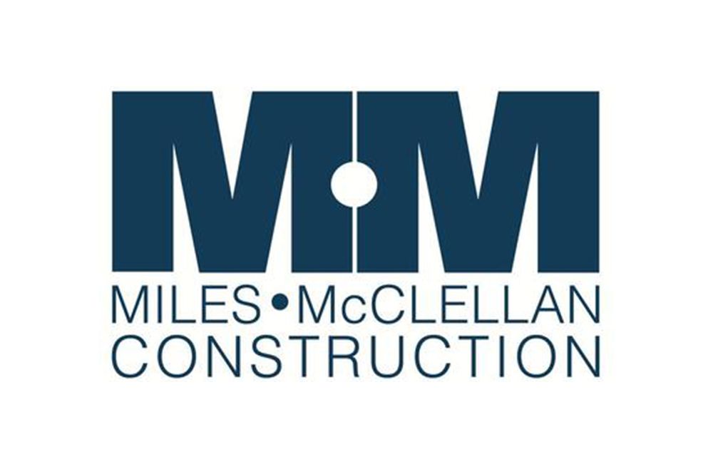 the logo for miles mcclellan construction is blue and white .