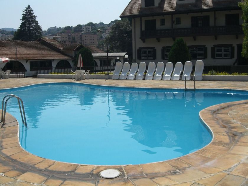 Uma grande piscina rodeada de cadeiras e guarda-sóis