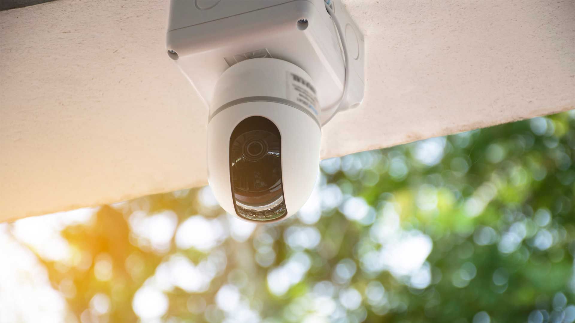 A security camera is hanging from the ceiling of a building.
