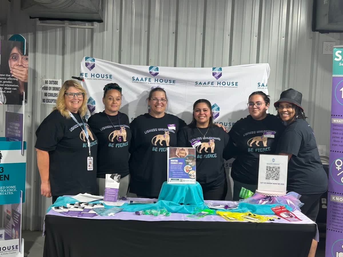 Six people at a booth with a 