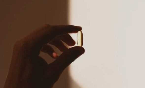 Vrouw houdt een pil in haar hand