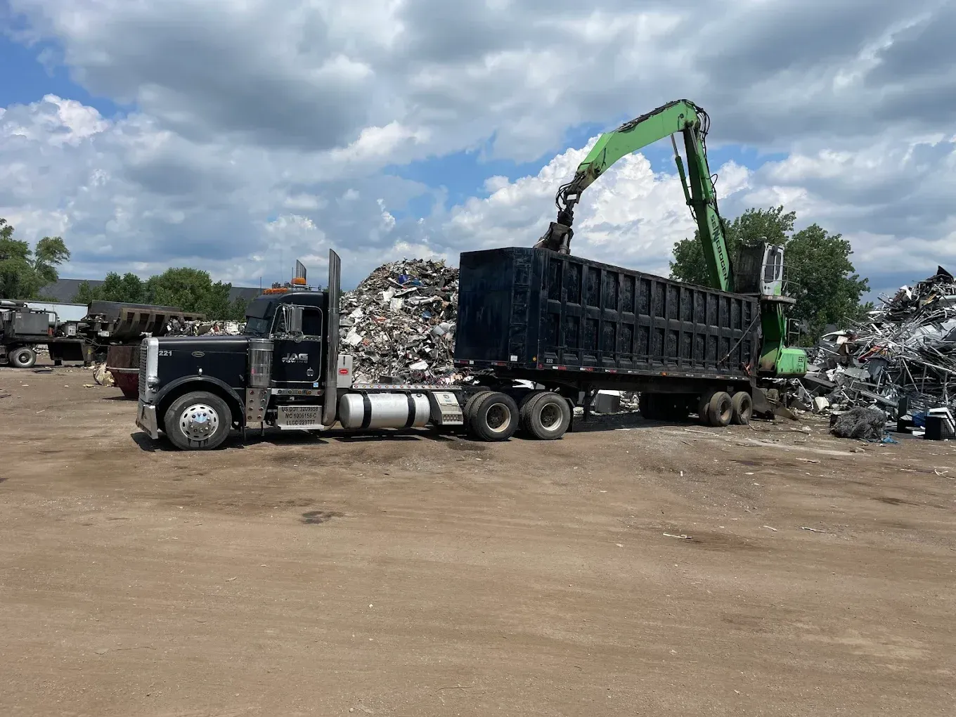 A car is being towed by a truck on a trailer.