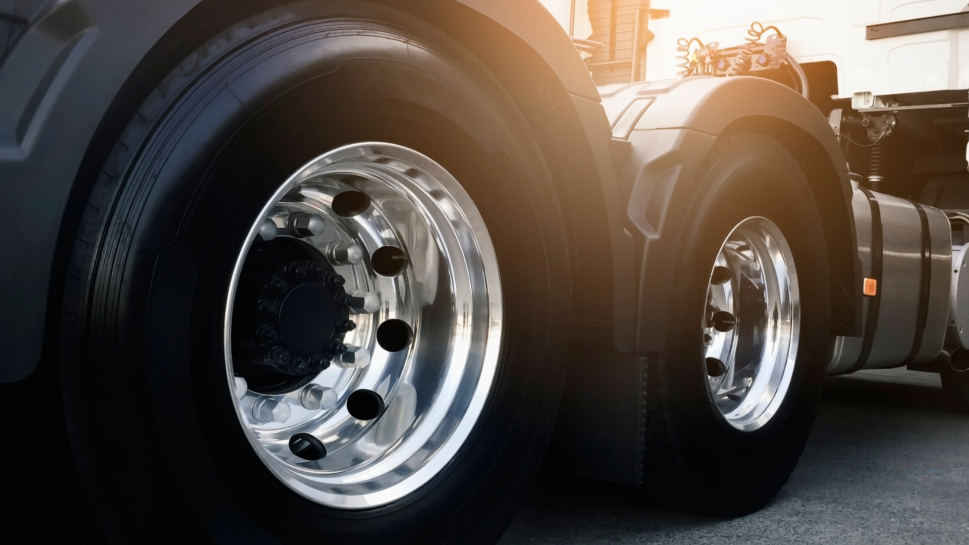 A blue suv is parked in front of a house with a trailer attached to it.