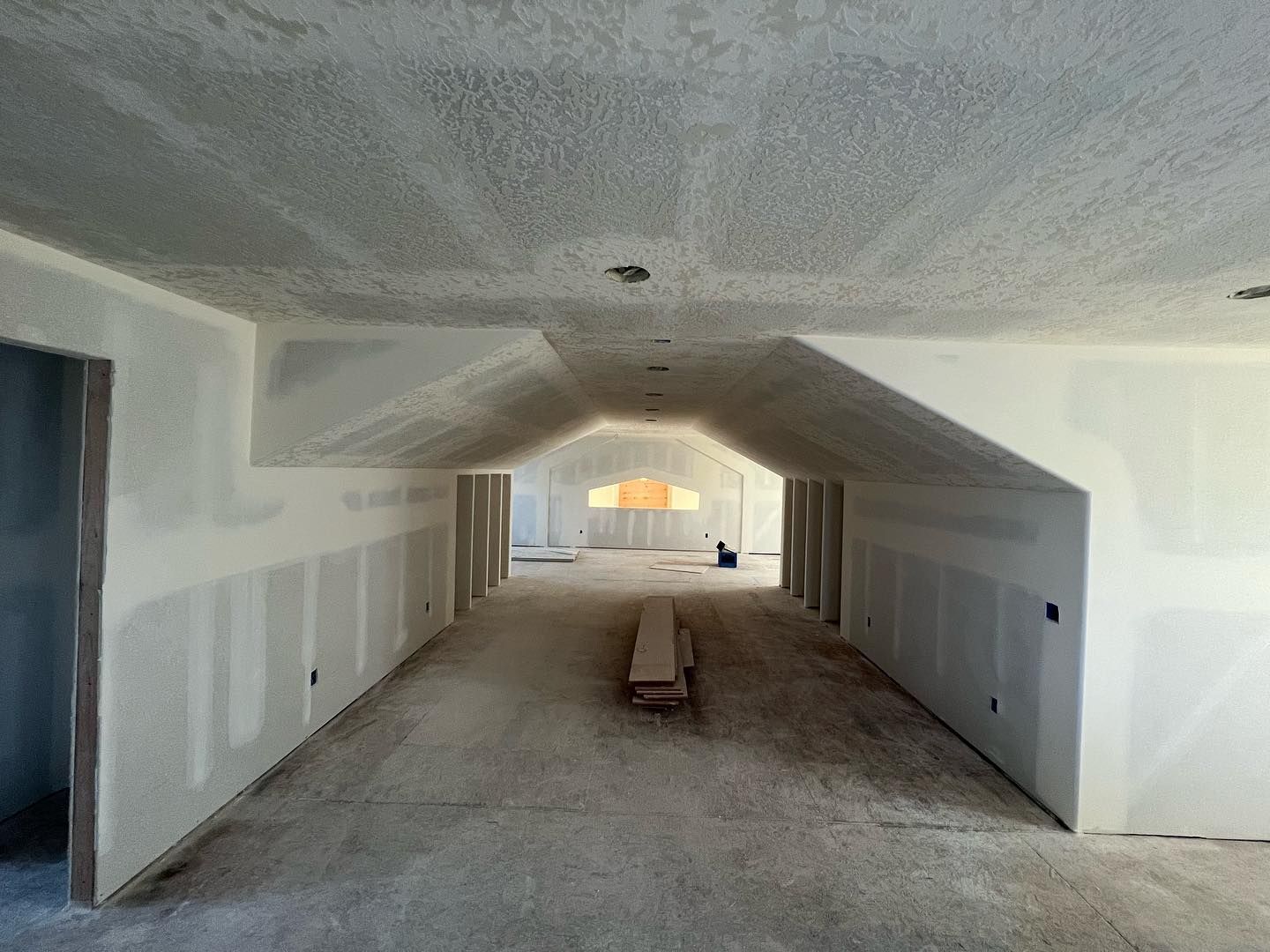 Interior room under construction, with drywalls and ceiling