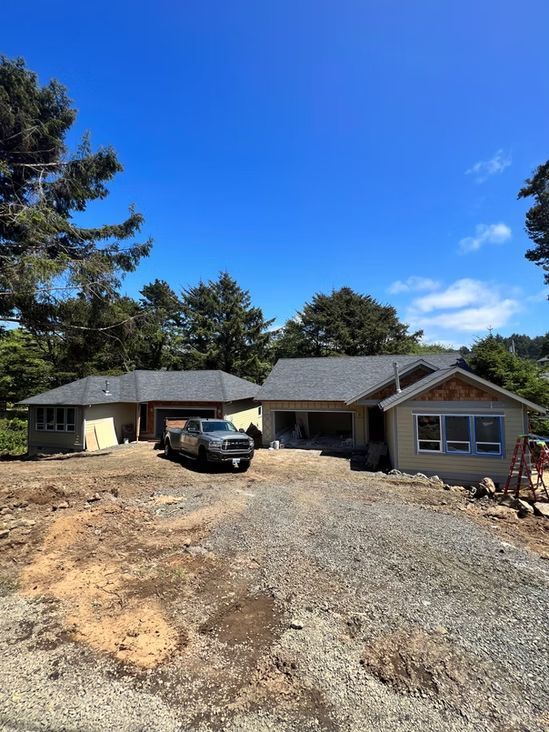 Construction site with two houses, truck, and clear blue sky