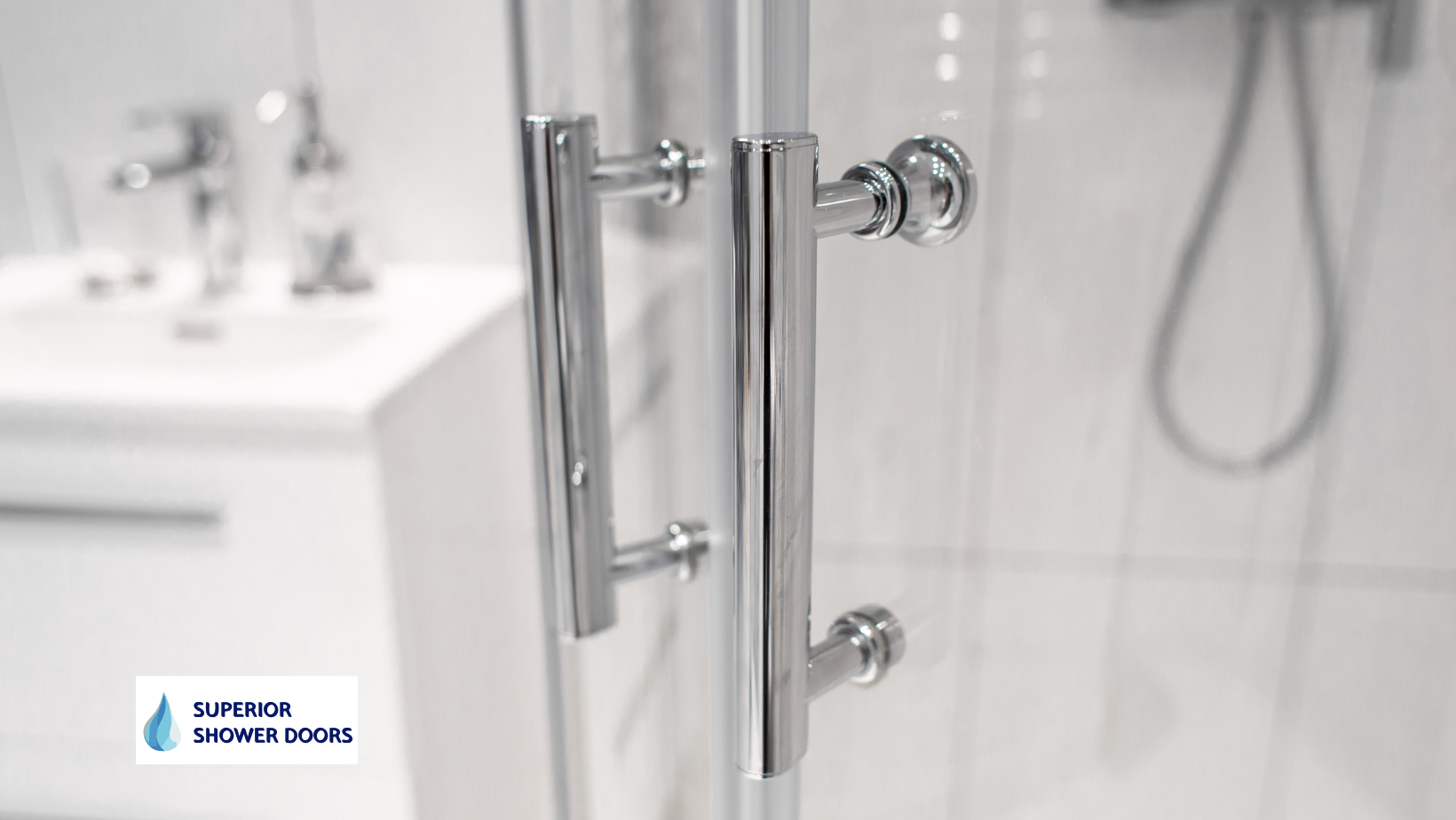 A close up of a shower door with a handle in a bathroom.