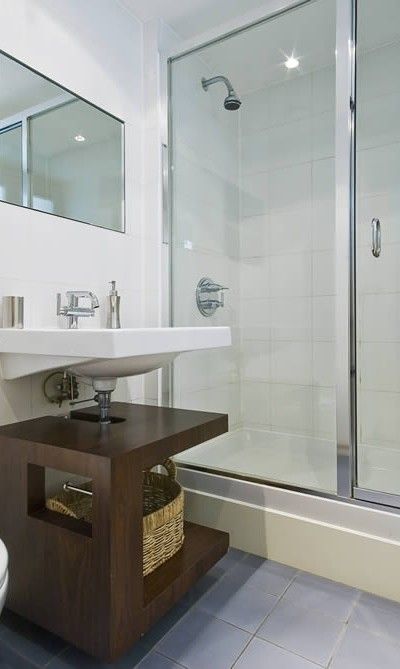 A bathroom with a sink and a walk in shower.