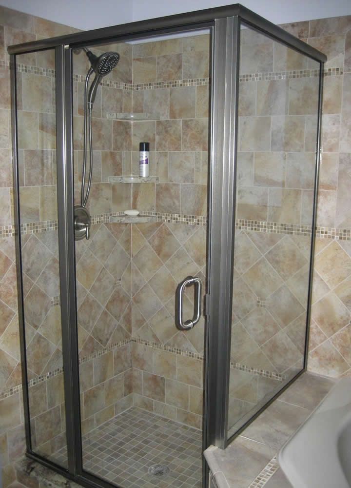 A shower stall with a glass door and a shower head