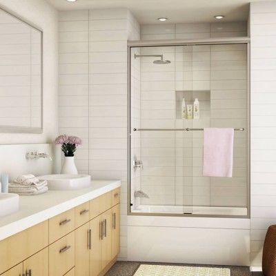 A bathroom with a sliding glass shower door and a sink
