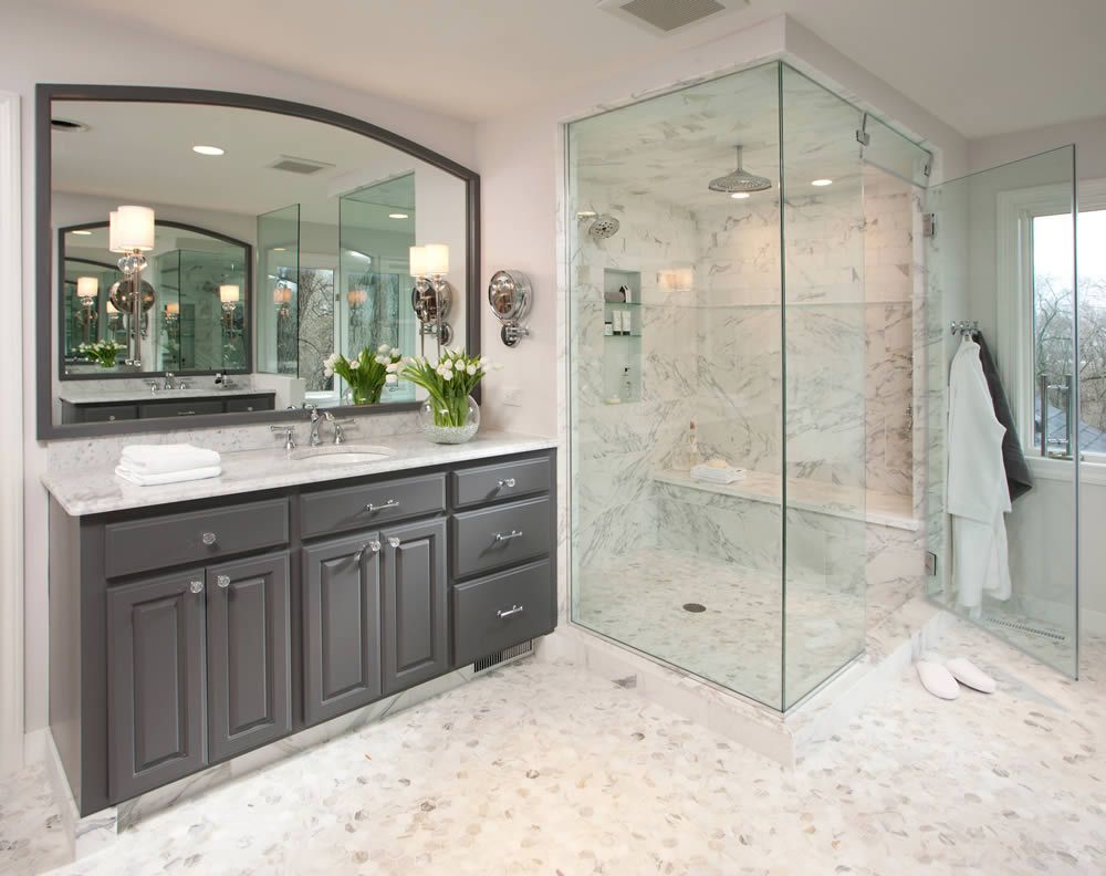 A bathroom with a walk in shower and a large mirror.