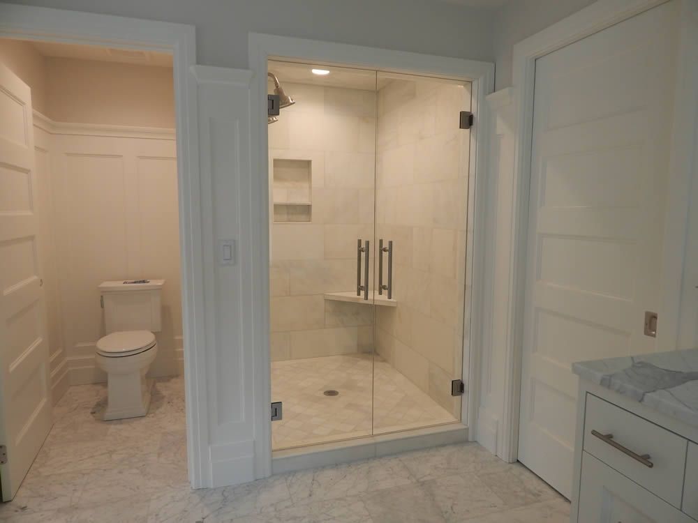 A bathroom with a toilet and a walk in shower.