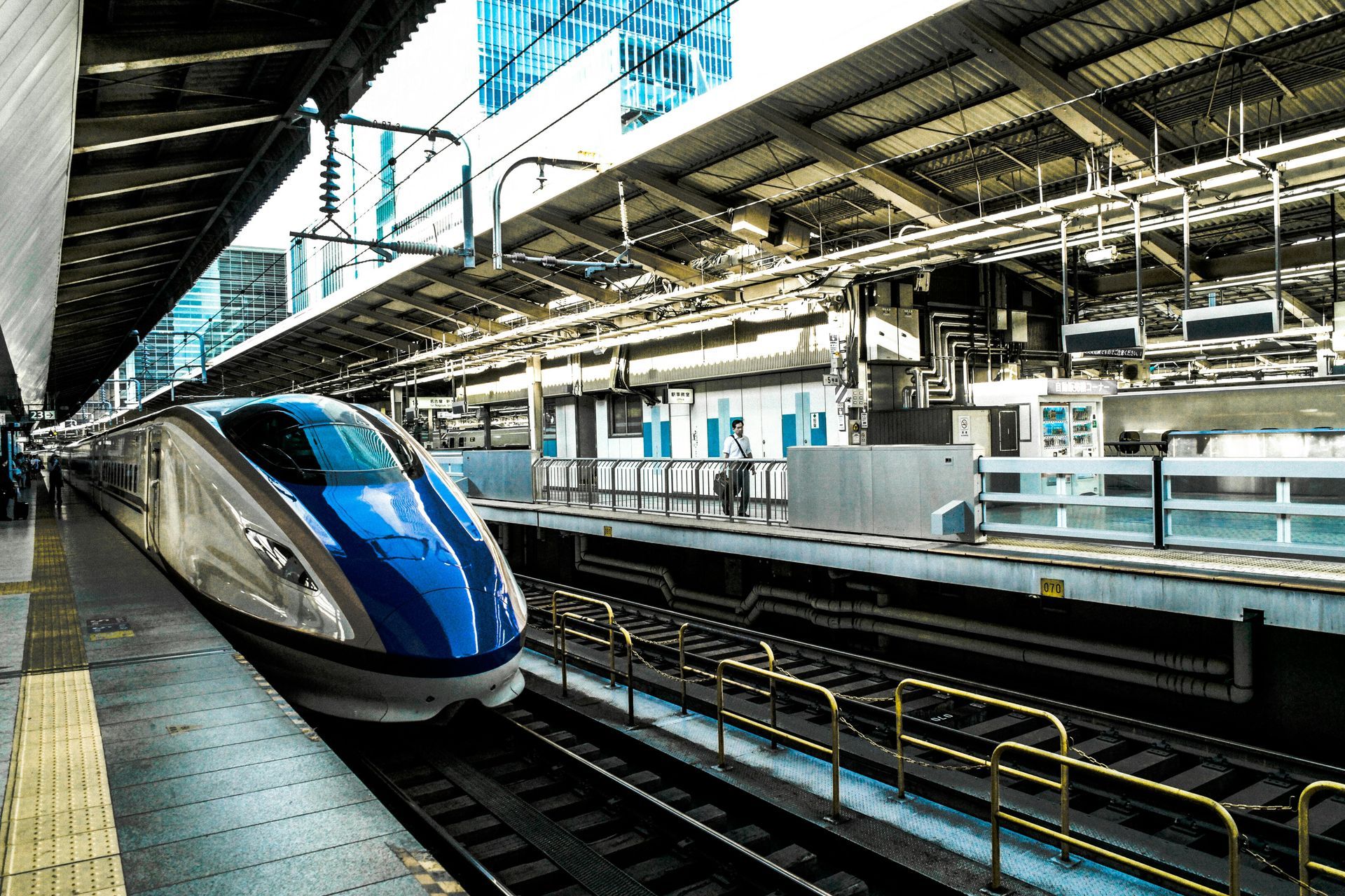 High-speed train in a station, blue and white with sleek design.