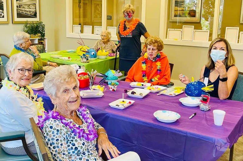 A group of people are sitting at a table with a purple table cloth.