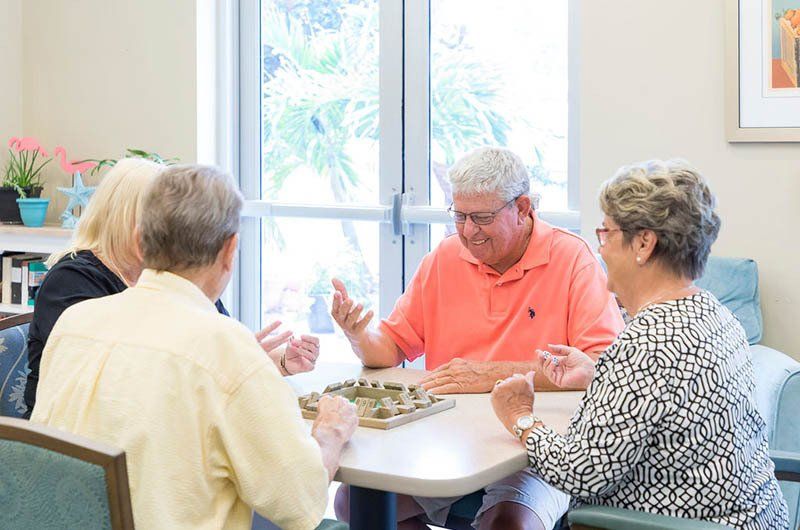 A group of elderly people are sitting around a table playing a game.