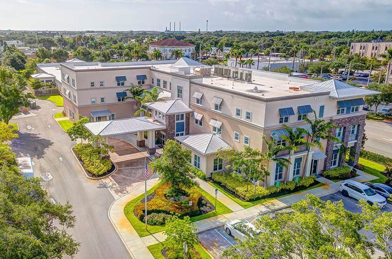 An aerial view of a large building with a lot of cars parked in front of it.