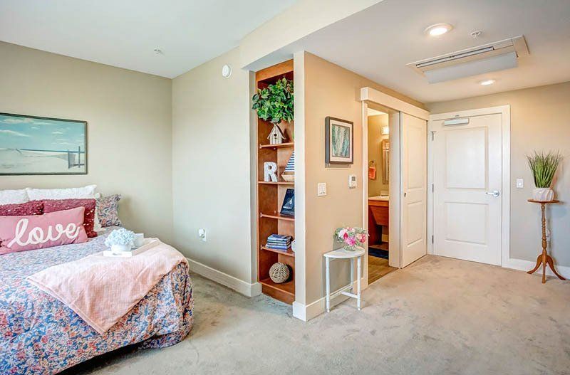 A bedroom with a bed , shelves , and a bathroom.