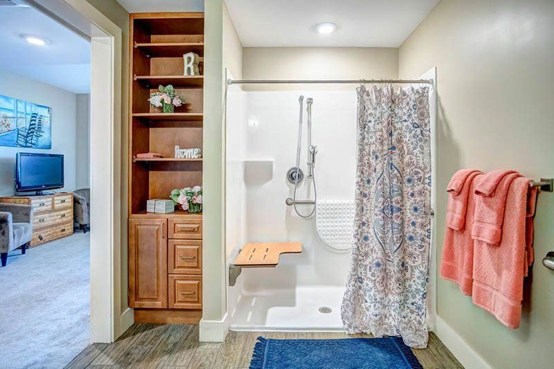 A bathroom with a walk in shower and a bench.