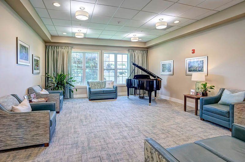 A living room filled with furniture and a piano.