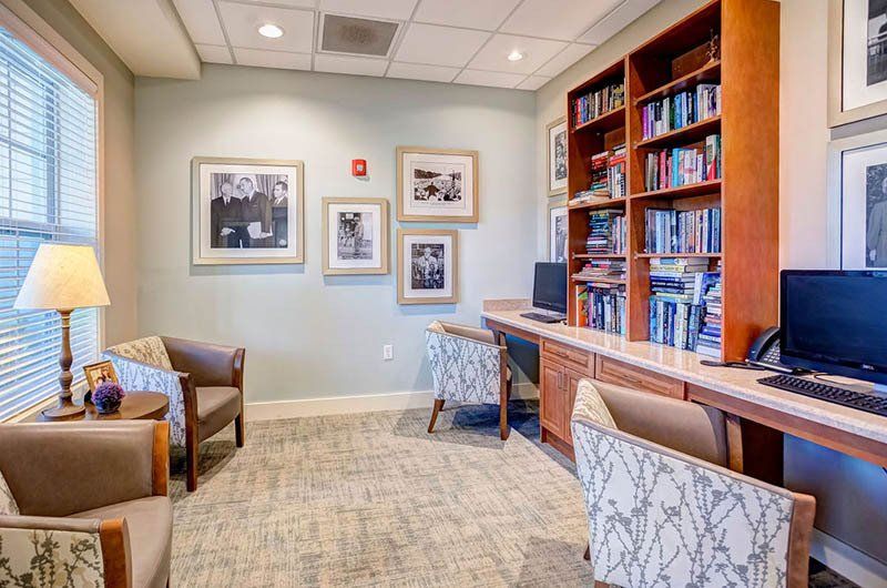 A living room with chairs , a desk and a computer.