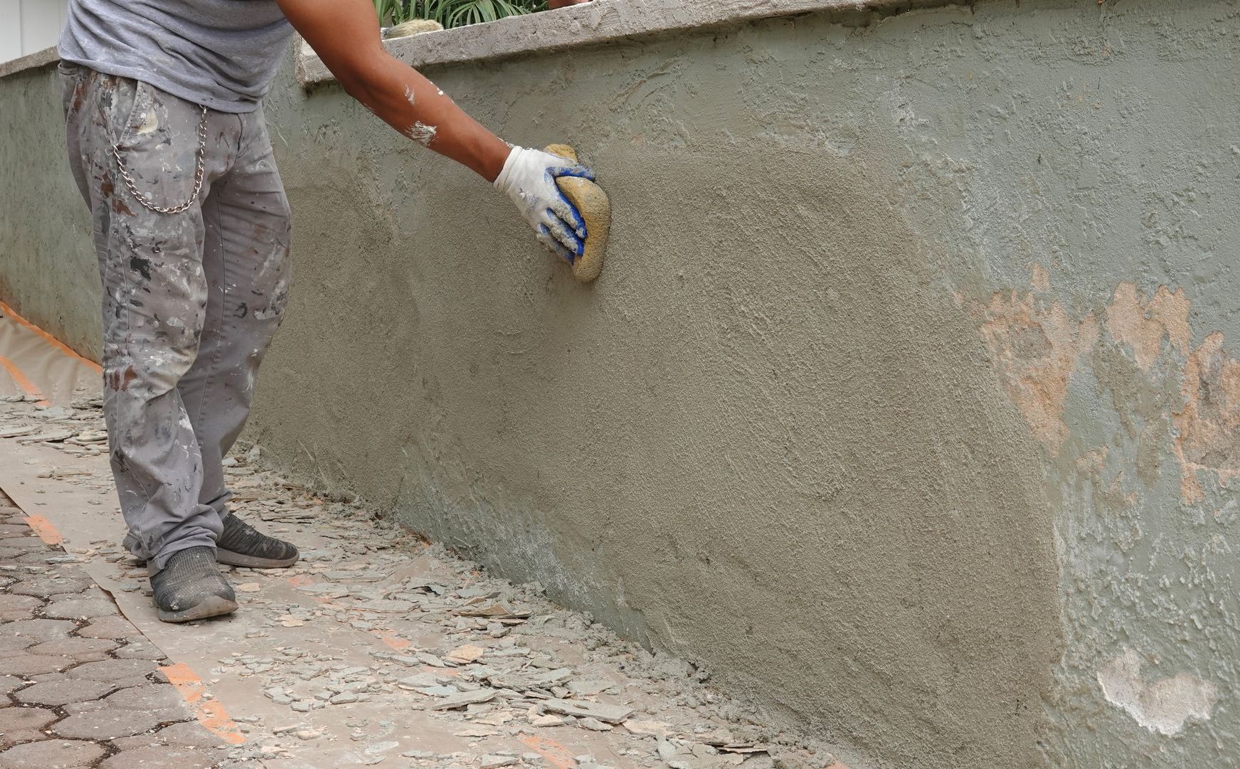 a man is cleaning a wall with a sponge .
