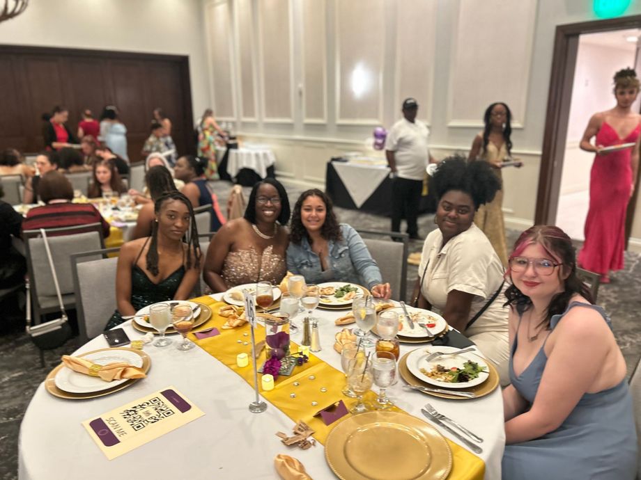 A group of women are sitting at a table with plates of food.