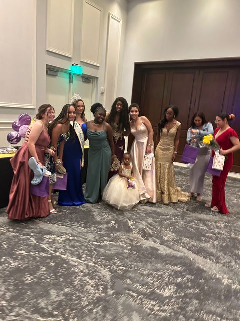 A group of women are posing for a picture in a room.