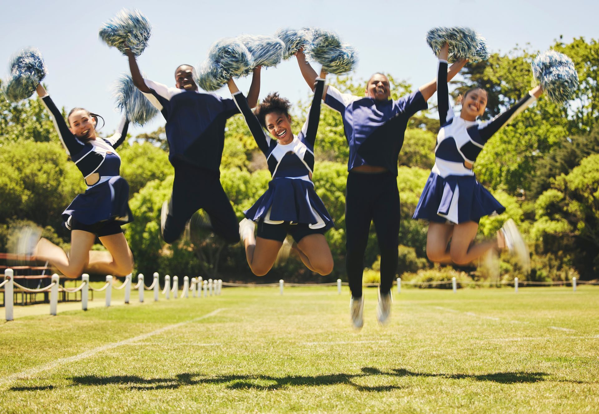 A group of cheerleaders are standing next to each other holding pom poms.