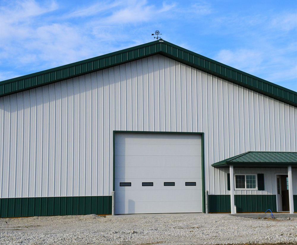 A White Building With A Green Roof And A White Garage Door — Sattin's Metal Roofing In Kiama, NSW