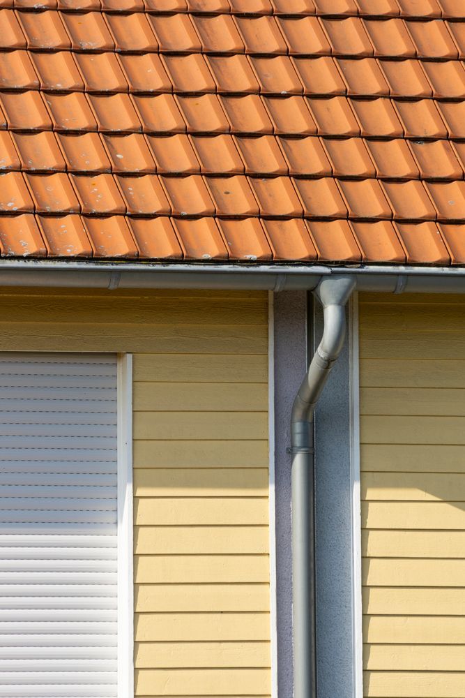A Yellow House With Orange Tiles On The Roof — Sattin's Metal Roofing In Shellharbour, NSW