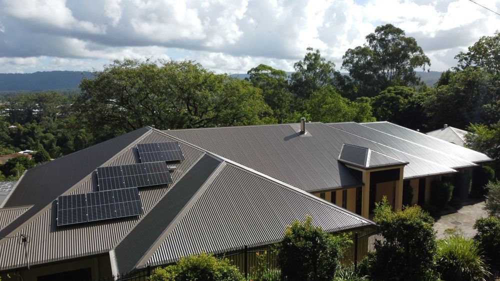 An Aerial View of A House with Solar Panels on The Roof — Sattin's Metal Roofing In Avondale, NSW
