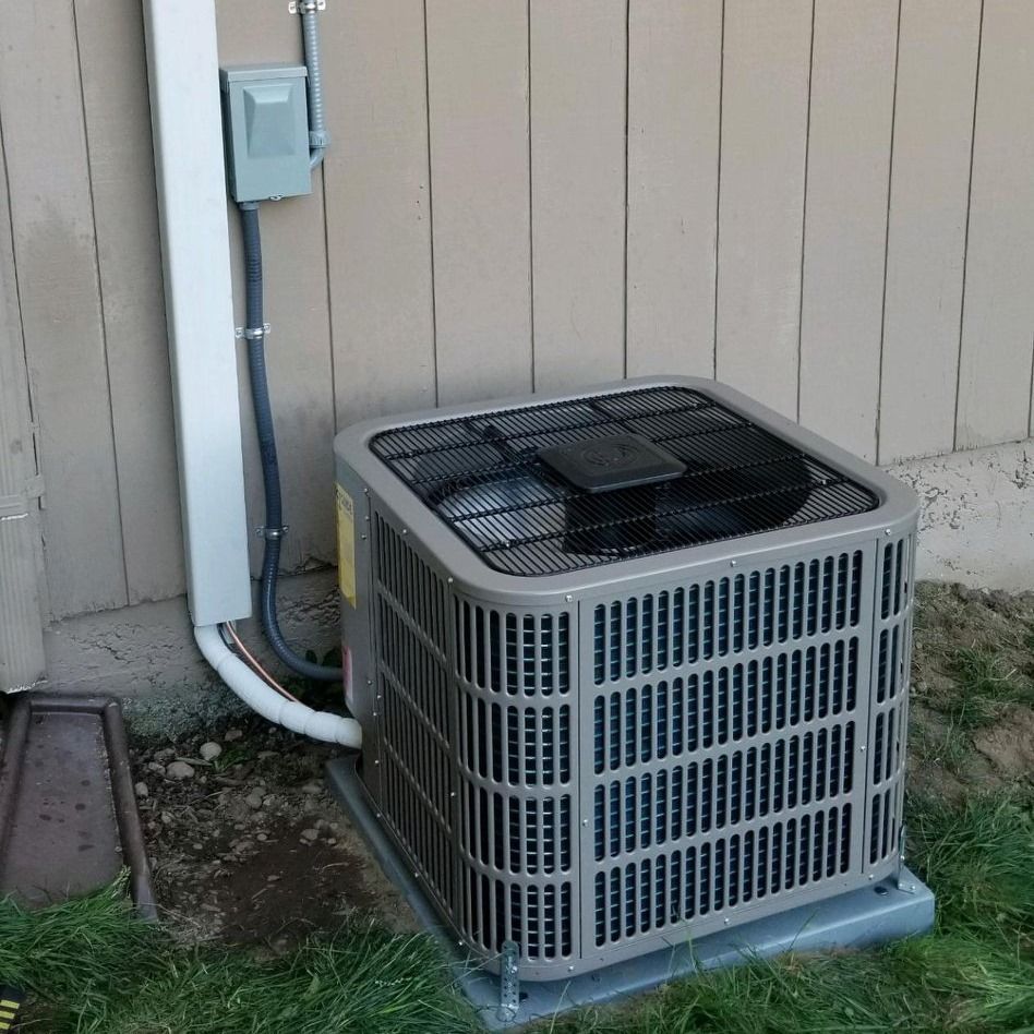 Air conditioning unit outside a building, with electrical components mounted on the wall.