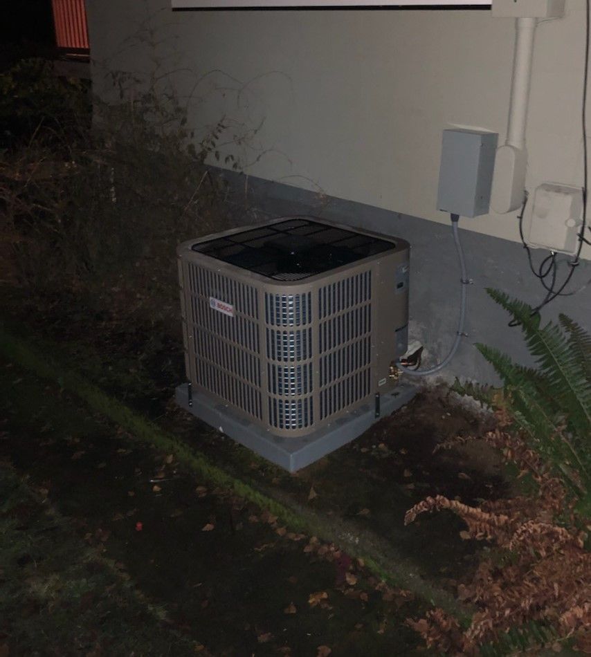 Air conditioner unit outside a building at night.