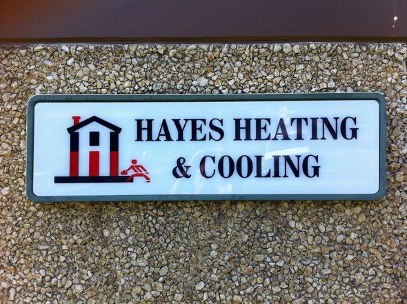 Sign for Hayes Heating & Cooling with house graphic and running figure.