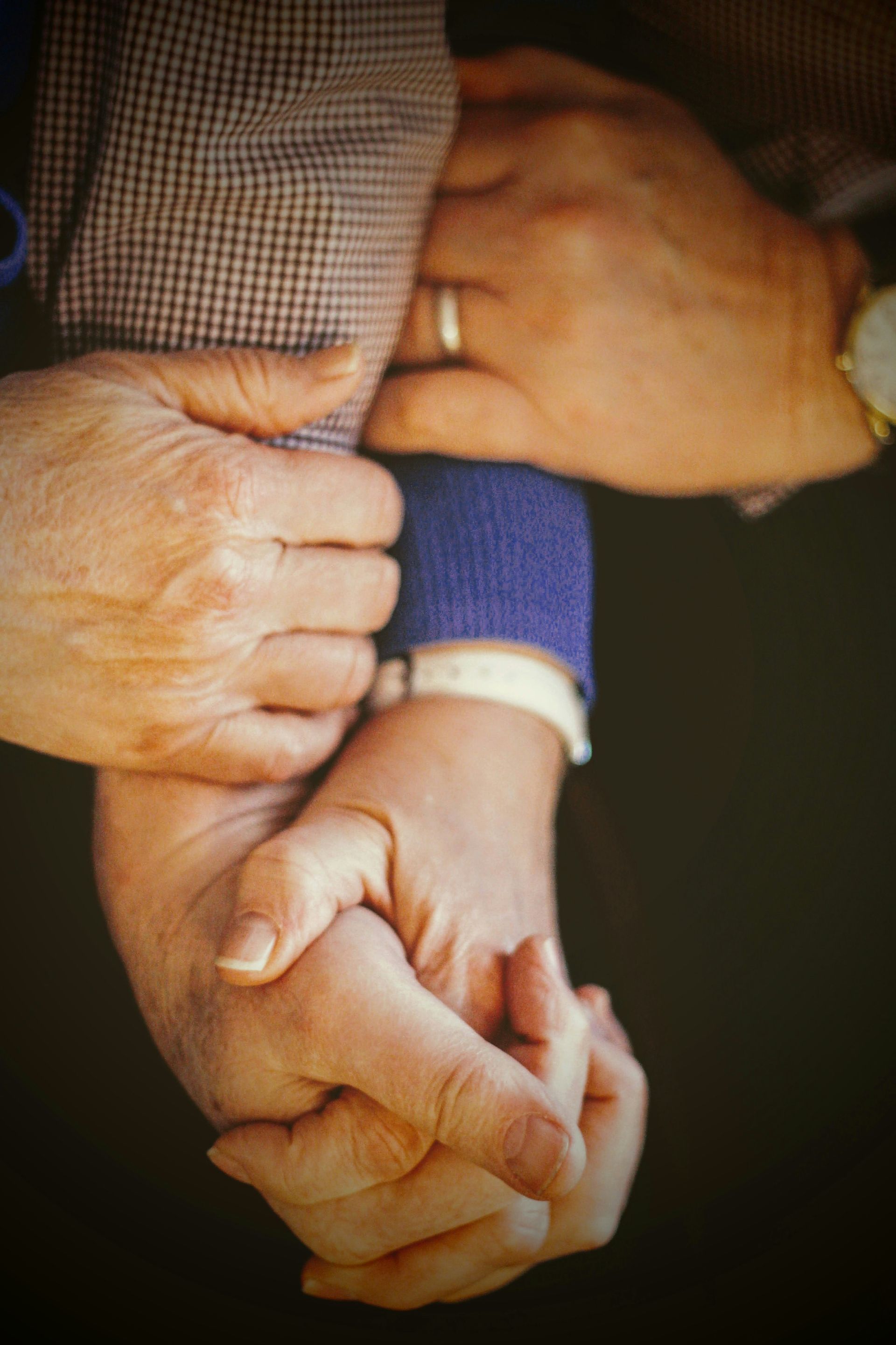 A group of people holding hands with one wearing a wedding ring