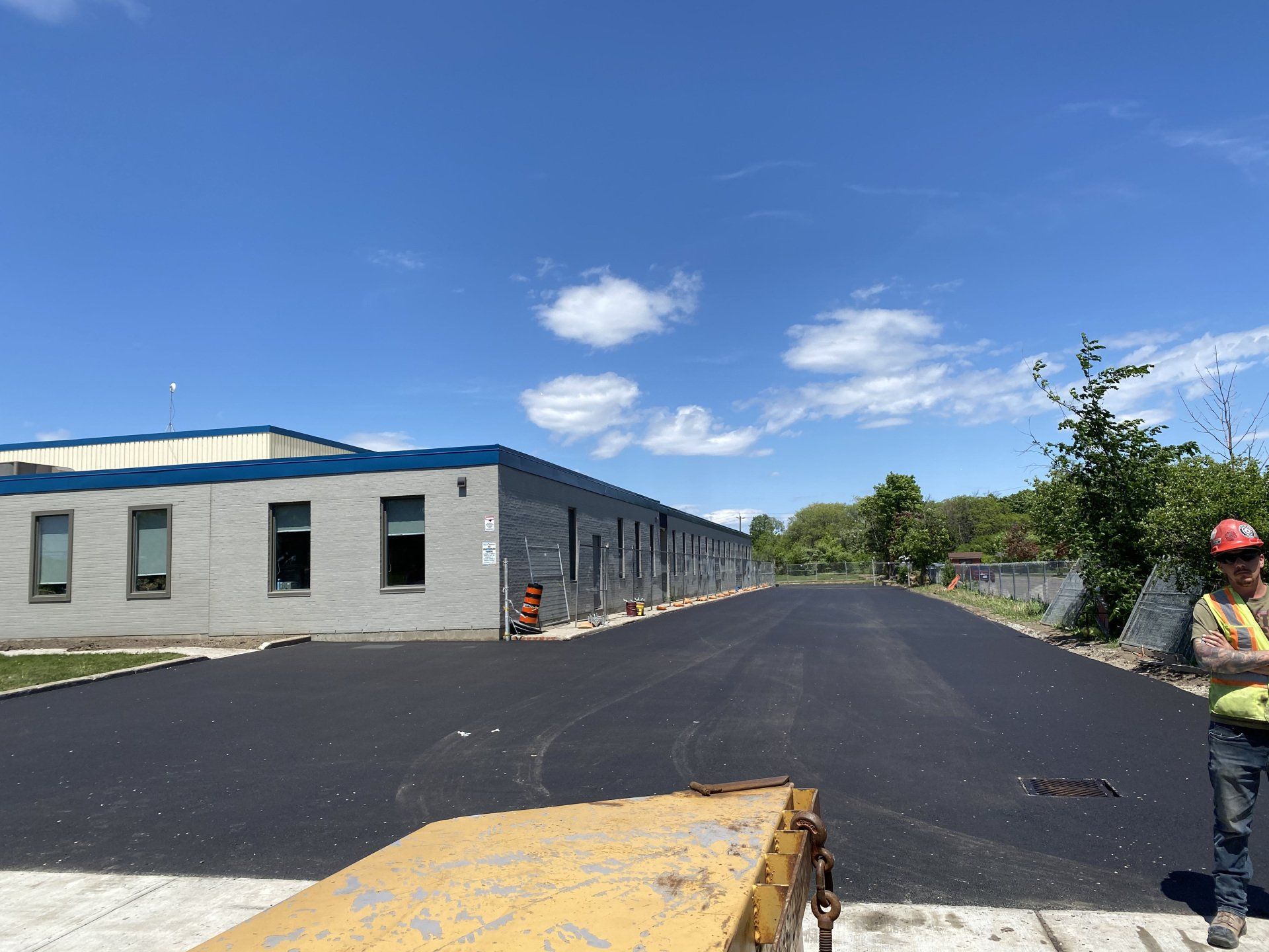 A man in a hard hat is standing in front of a building.